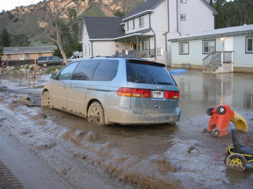 Car and houses surrounded by mud in mudslide - 2005.