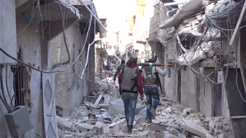 Rebels in Damascus walk through a bombed area, April 2017.