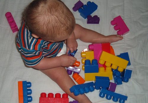 A child builds fine motor skills by playing with toys like these blocks.