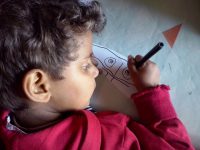 A child drawing with a pencil.