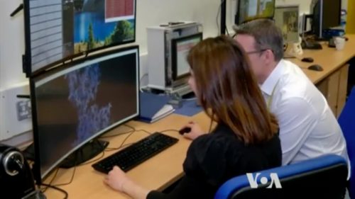 Scientists studying computer monitor.