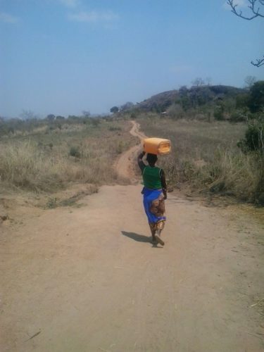 Woman walking to get water, Mozambique