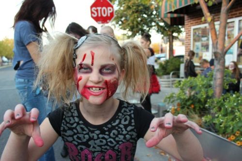 A young girl dressed up as a zombie for Halloween.