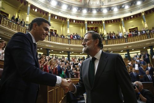 Pedro Sánchez (left) shakes hands with Mariano Rajoy (right).