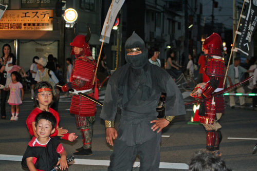 Ninja performer with kids at a festival.