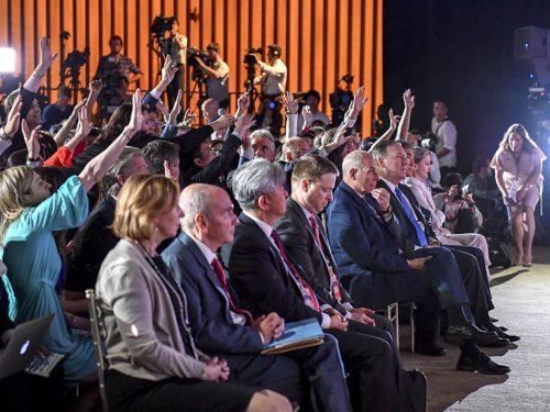 Reporters raise their hands to ask Mr. Trump a question.