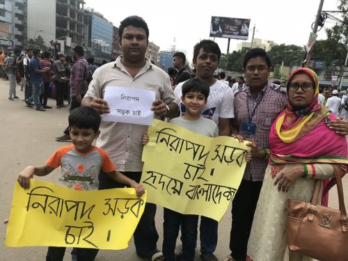 People of all ages protesting for safe roads with signs: "Want Safe Roads"