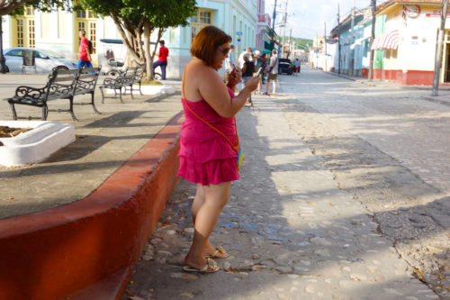 Woman in street looking at phone.