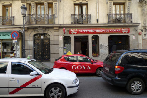 Taxi and car on Spanish street.