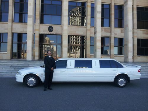 Chauffeur in front of white limoi