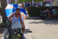 Girl on phone near plaza in Cuba.
