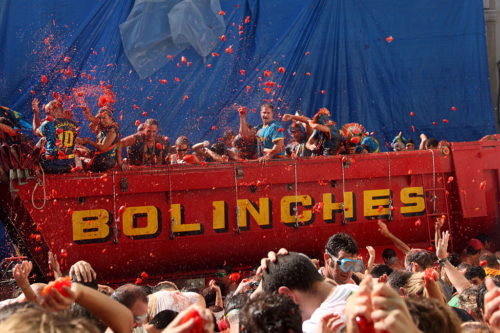 People throw tomatoes from a truck