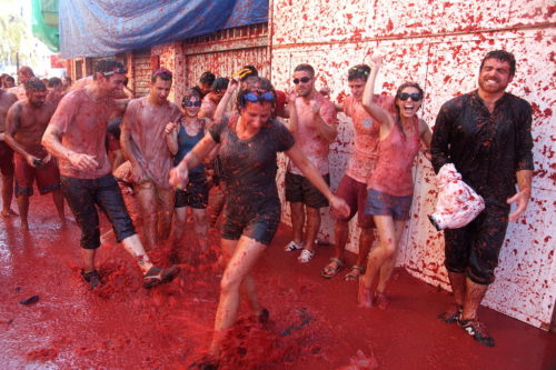 Crowd in a pool of tomato juice after a huge tomato fight.