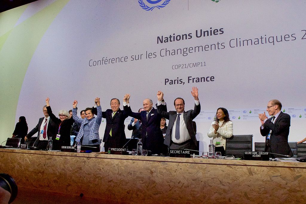 French Foreign Minister, UN Secretary-General Ban, and French President Hollande Raise Their Hands After Representatives of 196 Countries Approved a Sweeping Environmental Agreement at COP21 in Paris