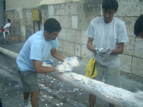 Two men grease a pole