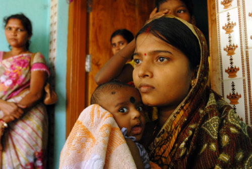 Womannd her baby boy Satyasworup pictured with family, back home from the neo-natal survival unit.