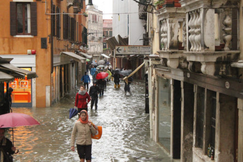 Pedestrians walking through flood tide waters in Venice in 2012.