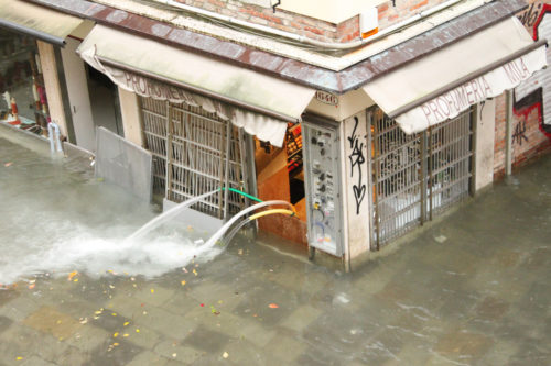 Water being pumped out of a flooded shop, Venice, 2012.