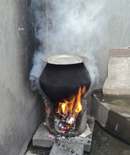 A rural stove using biomass cakes, fuelwood and trash as cooking fuel.