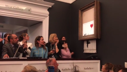 Screenshot of YouTube video by Banksy showing people reacting as painting shreds itself.