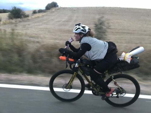 Ms. Graham riding on the road, an empty field in the background.