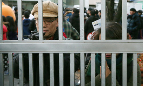 Parents praying at the gate of the testing center.