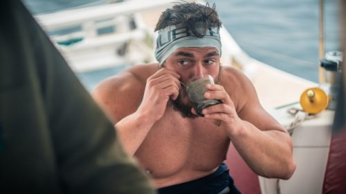 Mr. Edgley drinking from a cup before getting in the water.