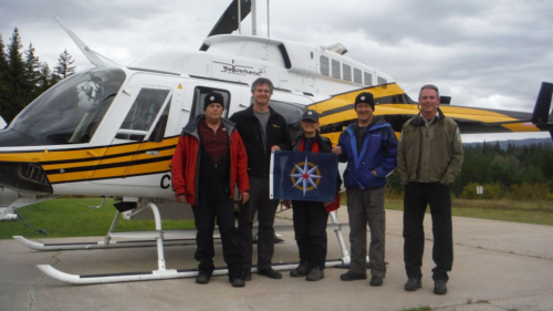 Team holding the Royal Canadian Geographical Society Flag after successfully completing the reconnaissance work. Left to right: John Pollack, Ken Lancour (Yellowhead Helicopters), Catherine Hickson (Tuya Terra Geo Corp.), Lee Hollis (Cody Cave), Tod Haughton (BC Park Official) (photo by self timer – John Pollack’s camera)