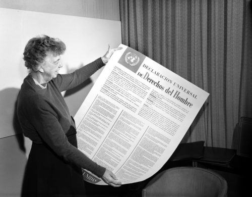 Eleanor Roosevelt of the United States holding a Universal Declaration of Human Rights poster in Spanish.