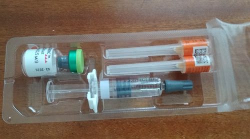Commercial vaccine for the prevention of measles, epidemic mumps and rubella. The bottle with the green cap at upper left contains a freeze-dried preparation of attenuated viruses. At the upper right are two hypodermic needles with protective caps. At bottom is a pre-filled solvent syringe.