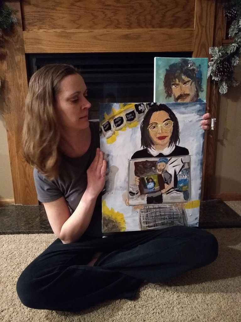 Woman holds two paintings of the four paintings that came before her.