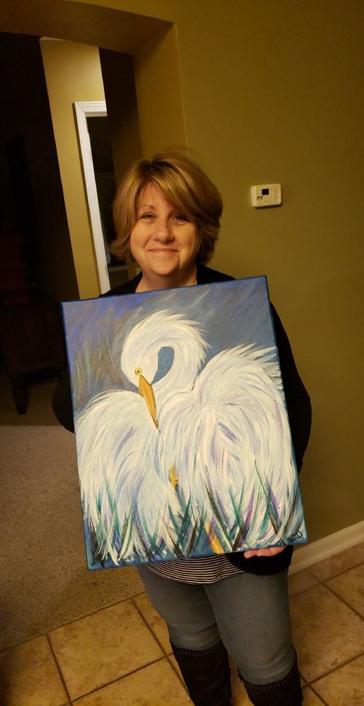 Original picture of Cindi Decker holding her painting of an egret.