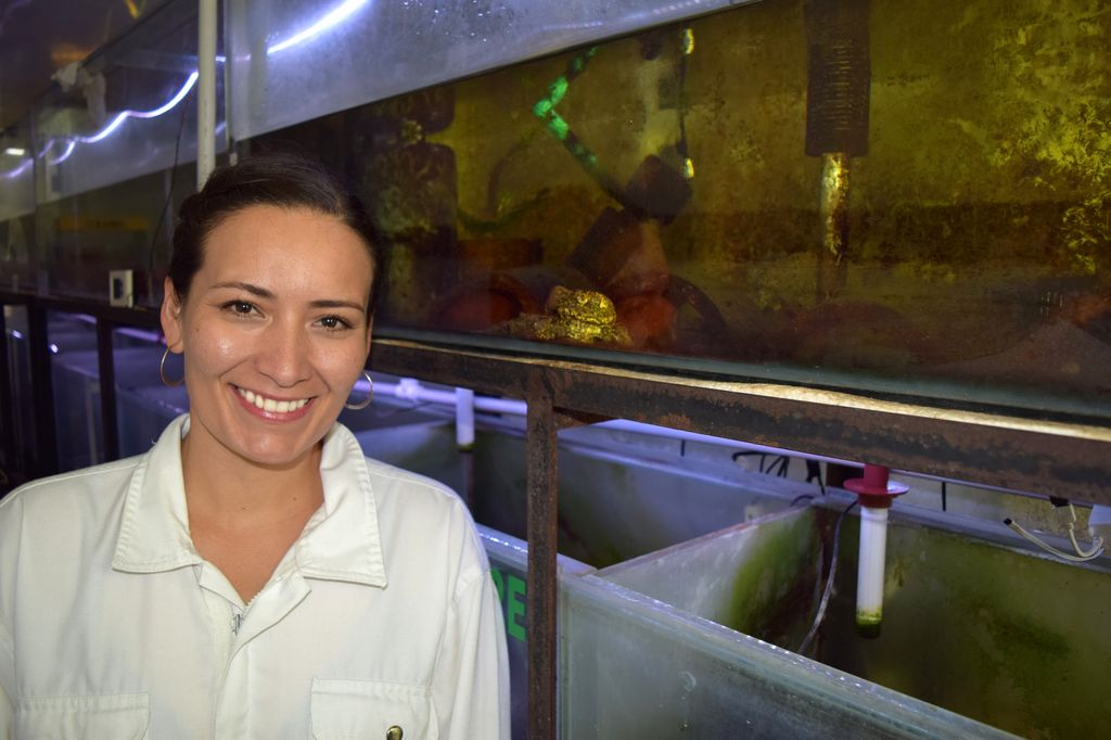 Teresa Camacho poses in front of aquariums.