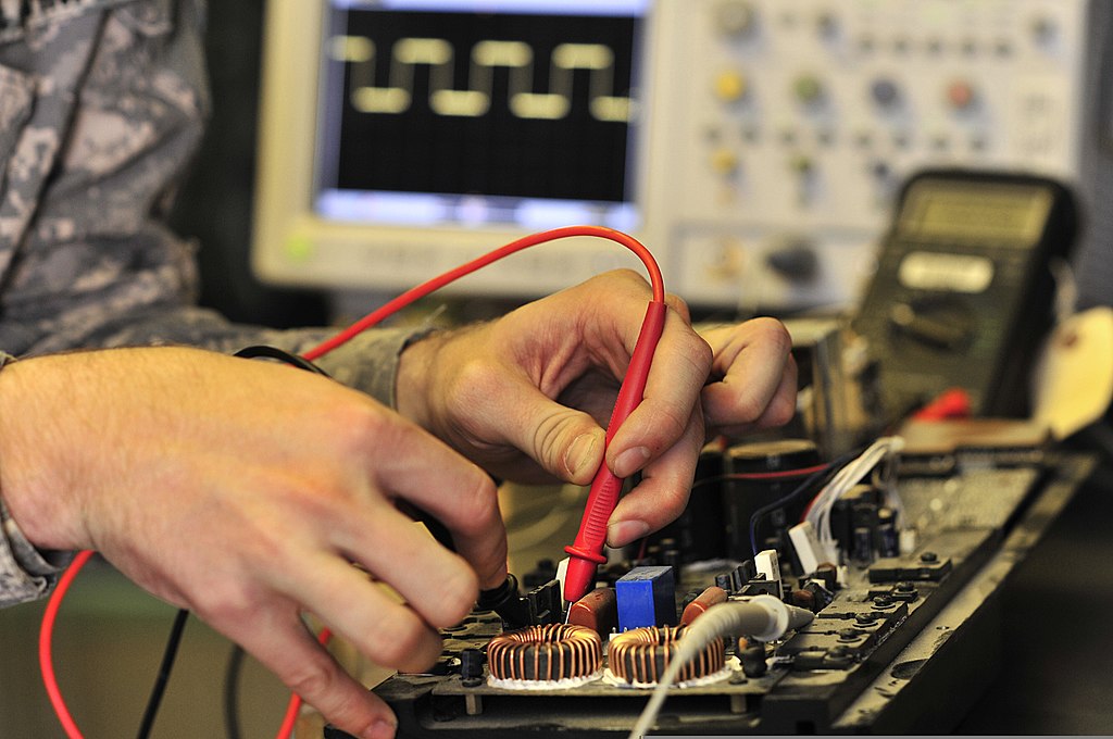 U.S. Army Pfc. John Howard fixes a public address system.