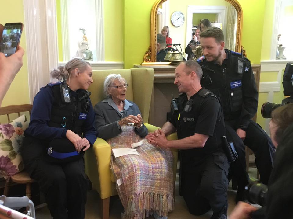 The Police officers chat with Anne as they put the handcuffs on.