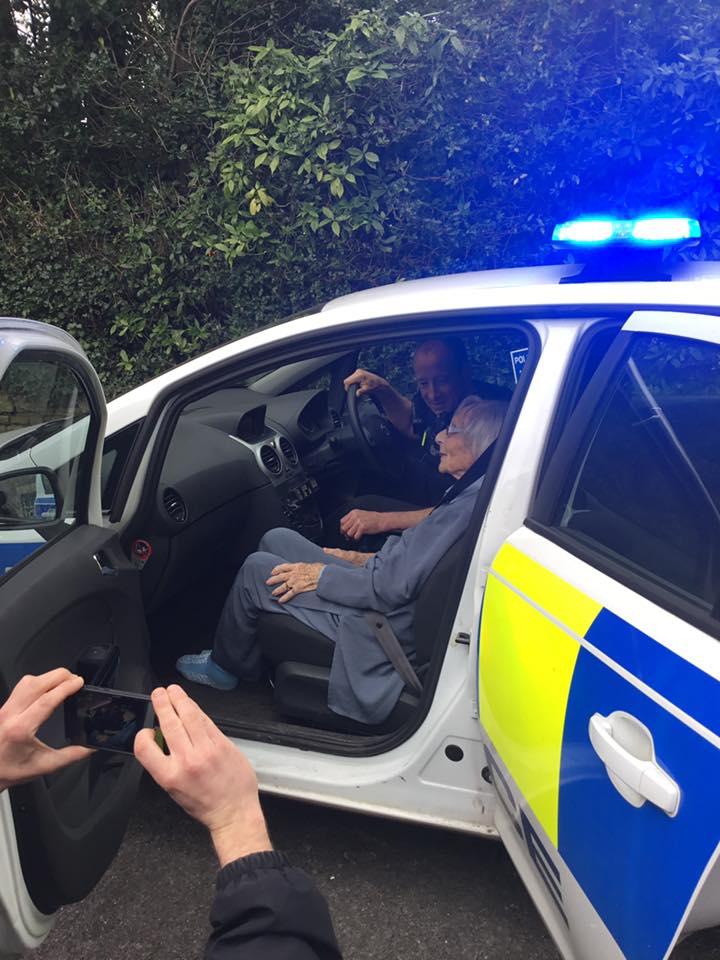 Anne seated in the police car.