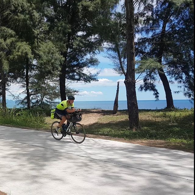 Charlie riding bike, sea in background.
