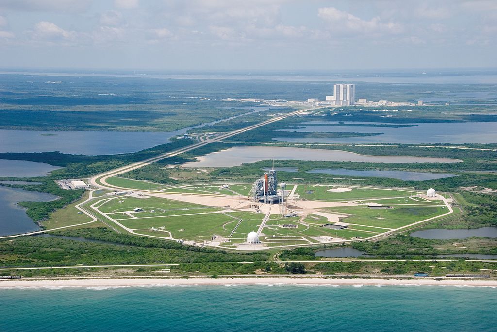 An aerial view of part of the Kennedy Space Center's giant complex featuring the Space Shuttle Endeavour and its support stack of hardware on launch pad 39A