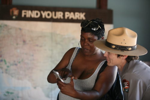 Woman and park ranger looking at phone