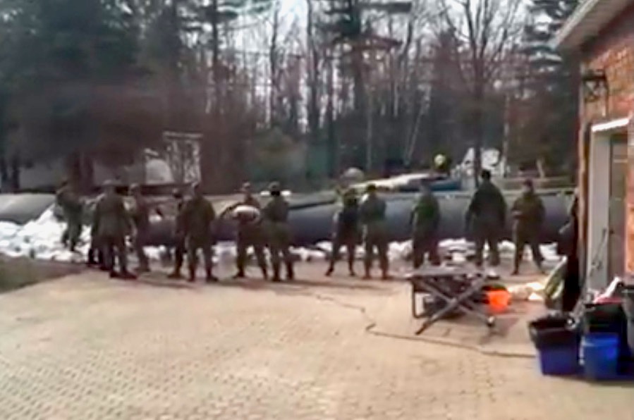 Members of Canada's Air Force move sandbags to support an emergency wall in Cumberland, Ontario.