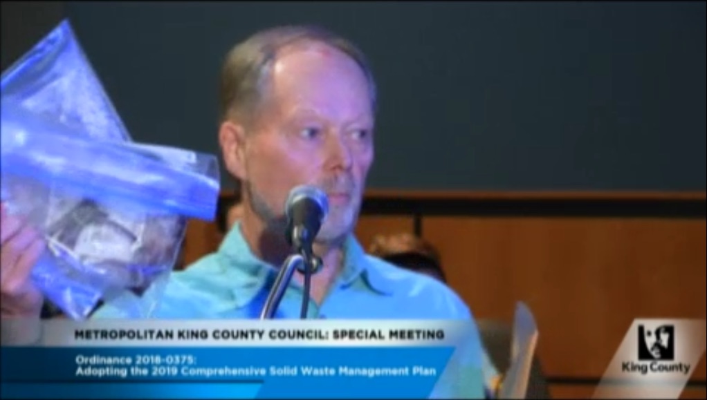 Dave Vogel holds up a bag of human at the King County counselor