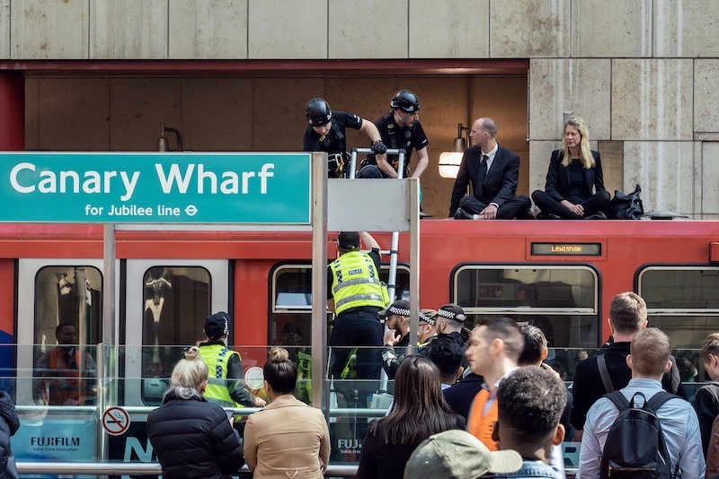 Three rebels obstructed the overground tube at Canary Wharf station today, remaining in place for about an hour before being taken away under arrest.