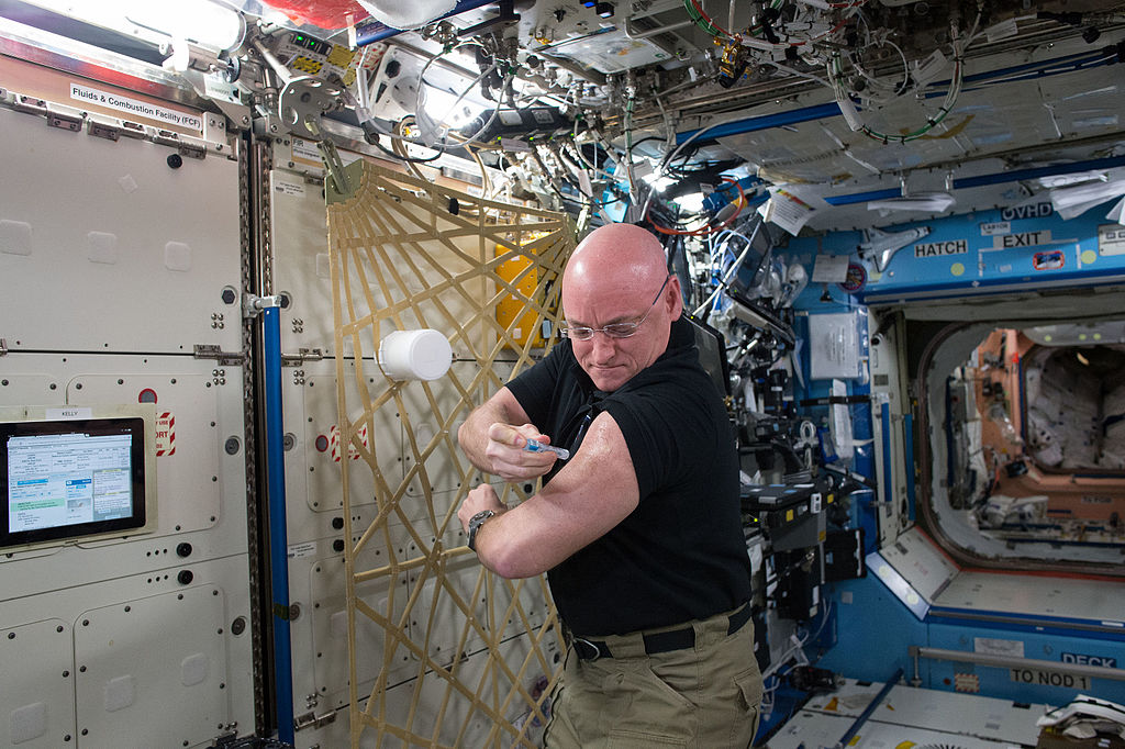 NASA astronaut Scott Kelly gives himself a flu shot for an ongoing study on the human immune system. The vaccination is part of NASA's Twins Study.