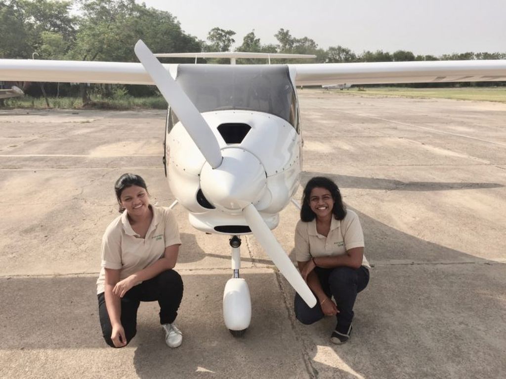 Aarohi Pandit and Keithair Misquitta in front of light sport aircraft.