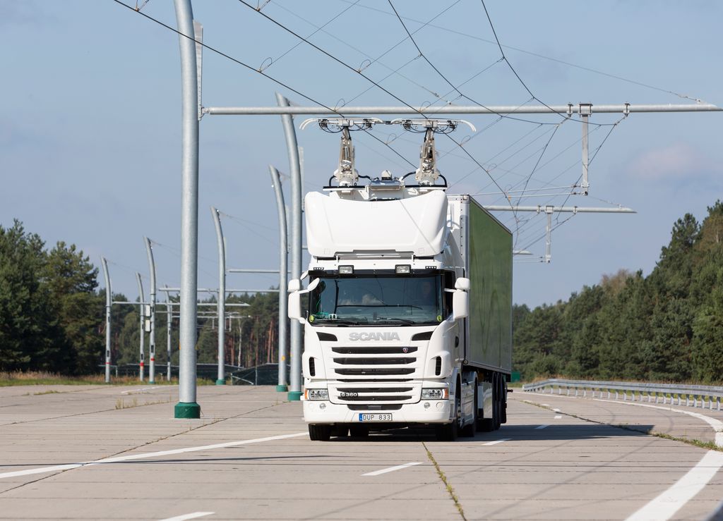 A hybrid truck travels on an eHighway, charging from an overhead cable system.