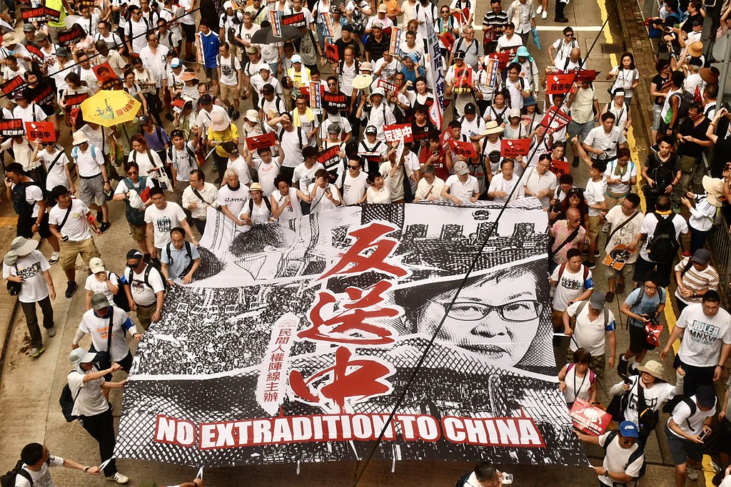 Protesters in white hold sign saying "No extradition to China" - (繁體）‎: 香港民陣估計103萬人參與6-9反送中大遊行。(美國之音湯惠芸拍攝)