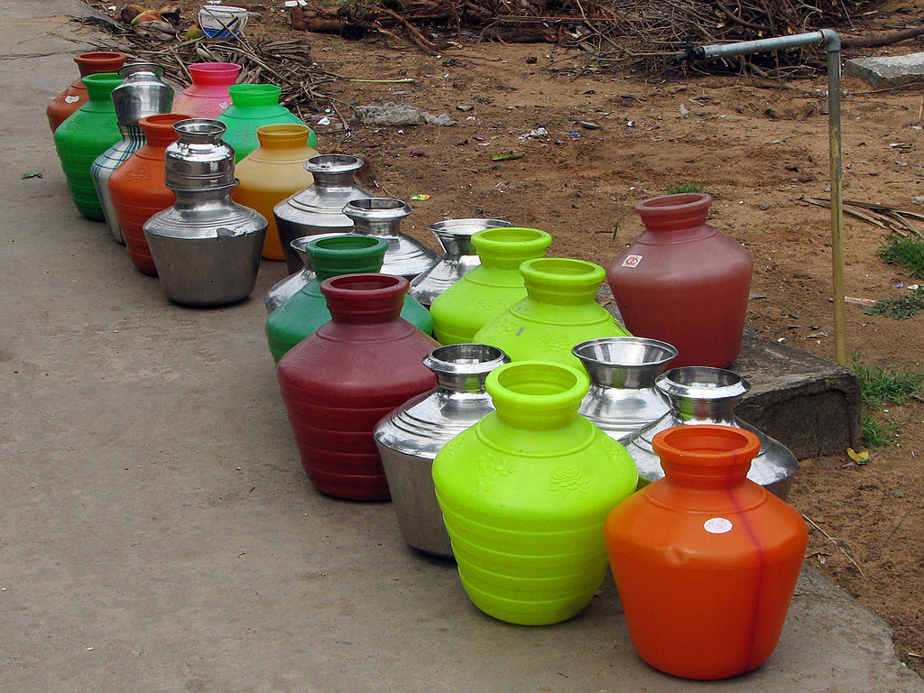 Bright multi-coloured water pots lined up to be filled at the street tap. These bright plastic jugs are ubiquitous in Chennai and Tamil Nadu.