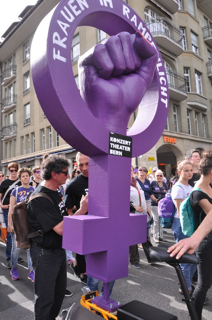 Giant purple female sign with a fist sticking out.