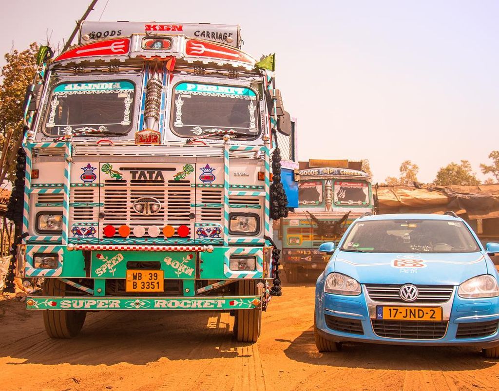 Wiebe Wakker's electric car trip, Blue Bandit next to decorated bus in India