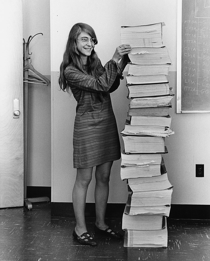 Margaret Hamilton standing next to the navigation software that she and her MIT team produced for the Apollo Project.